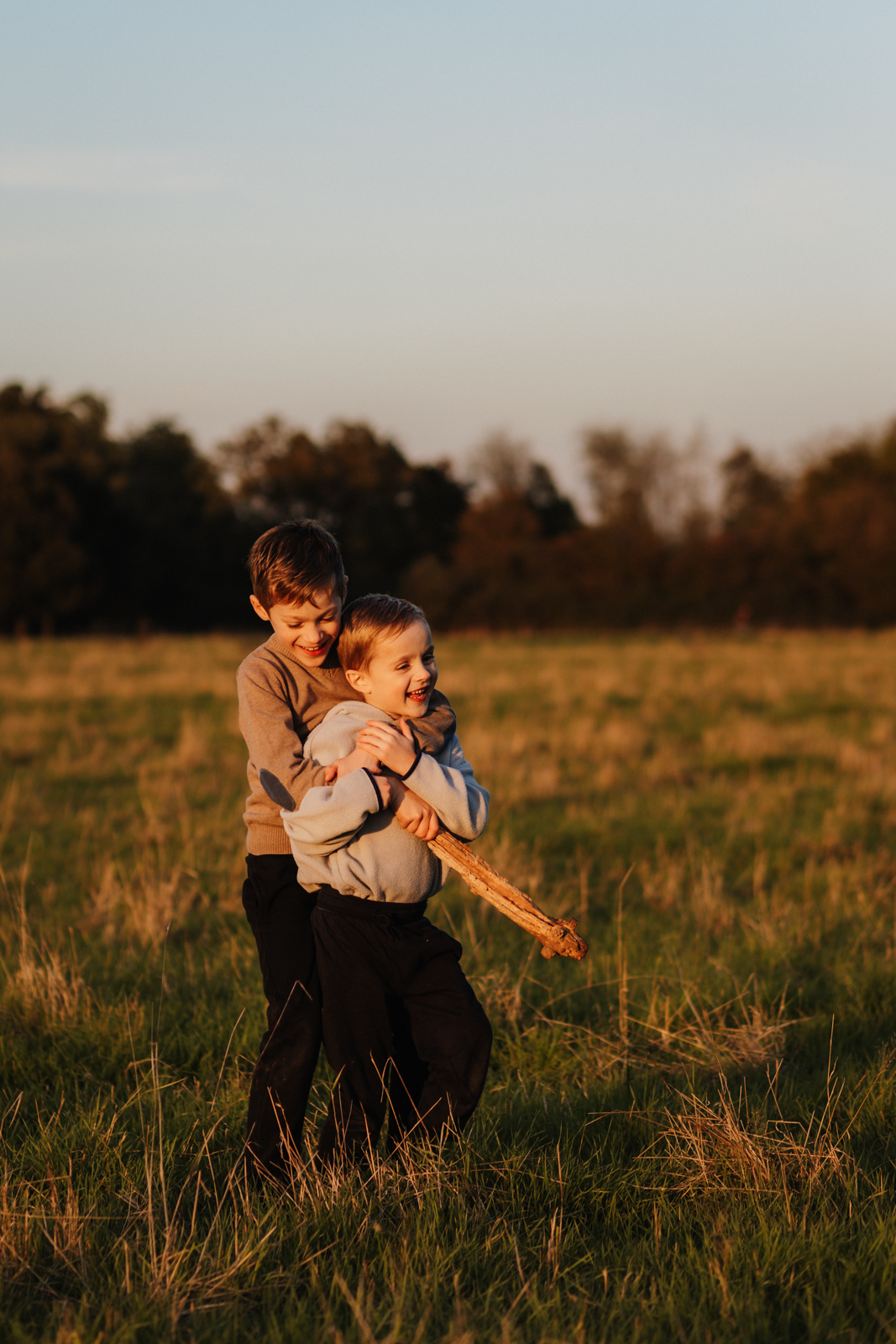 Zwei Jungen, die im Sonnenuntergang toben und lachen