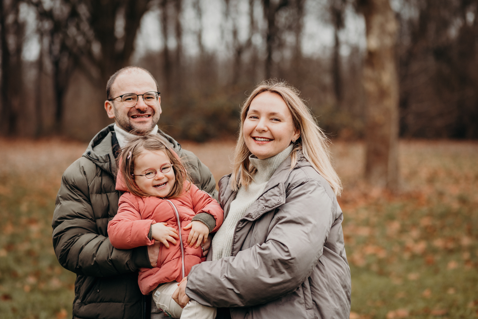 Mama und Papa glücklich mit lachendem Mädchen auf dem Arm beim Familien Fotoshooting Köln