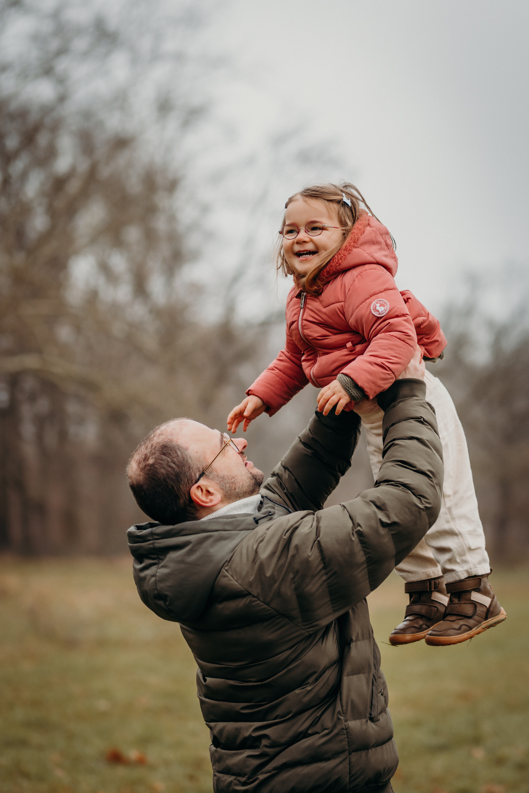 Vater wirft Kleinkind in die Luft – natürliche Familienfotografie Köln