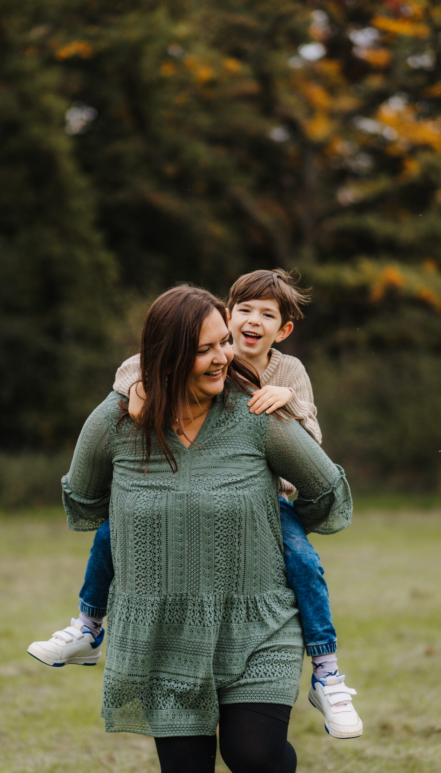 Mama trägt Sohn Huckepack – natürliche Familienfotografie Köln