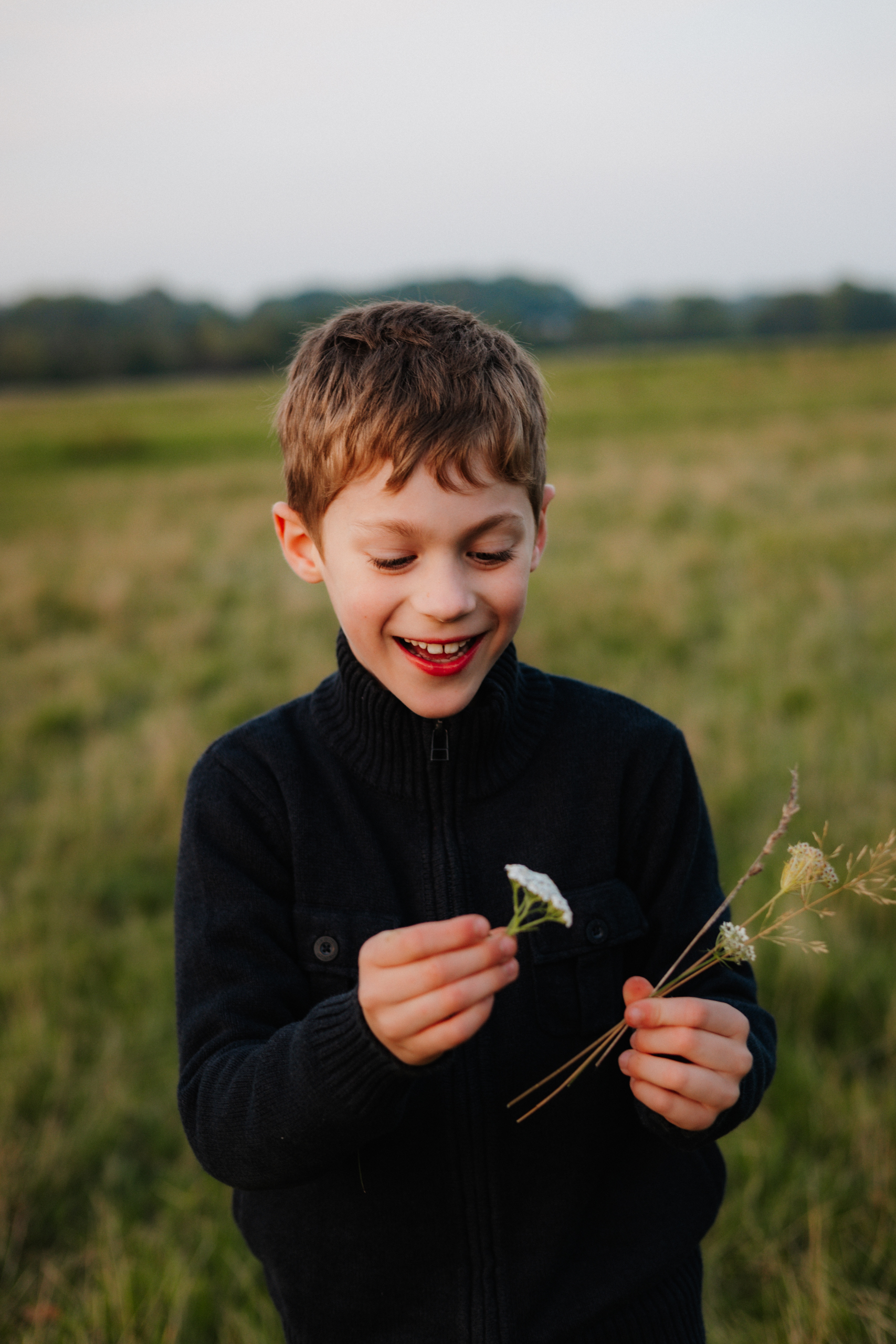 Junge freut sich über gepflückte Blumen