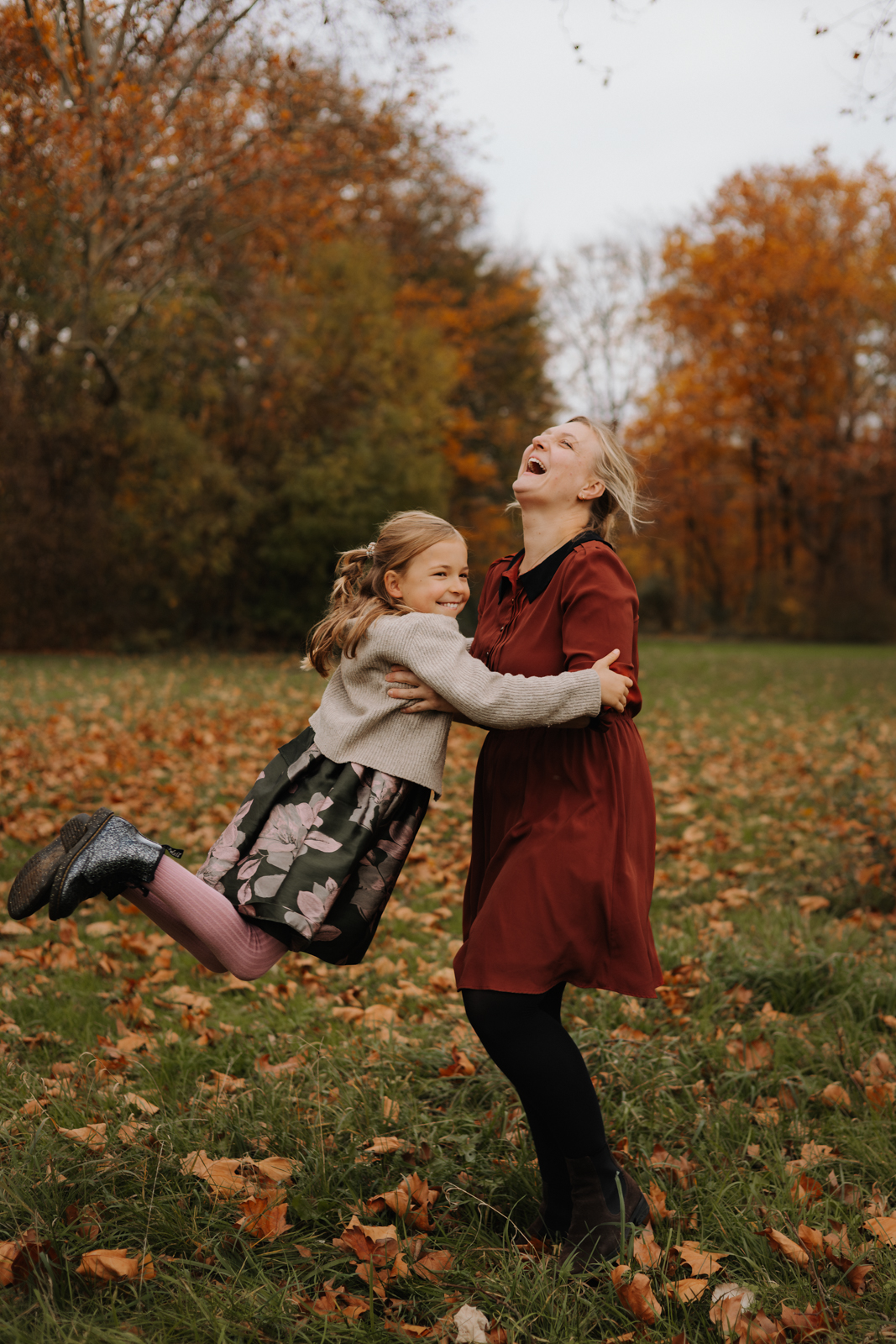 Mama dreht ihre Tochter lachend durch die Luft beim Familien Fotoshooting Köln