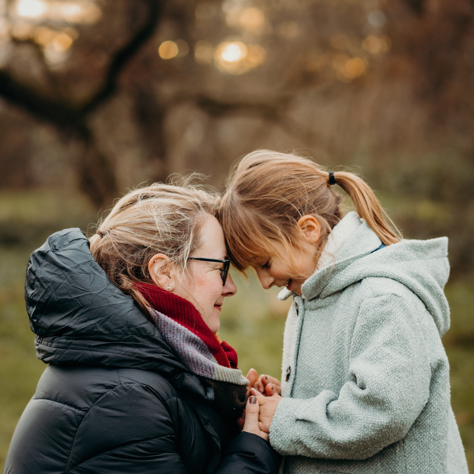 Mama und Tochter stehen Stirn an Stirn mit geschlossenen Augen bei einem natürlichen Mutter Kind Fotoshooting in Köln