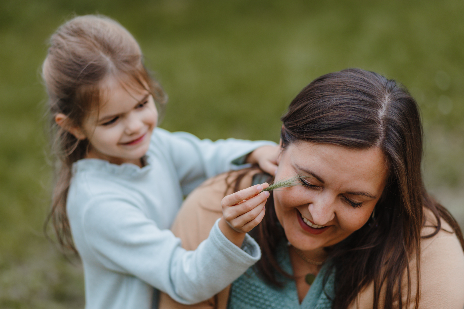 Kind kitzelt Mama spielerisch bei einem natürlichen Mutter Kind Shooting in Köln