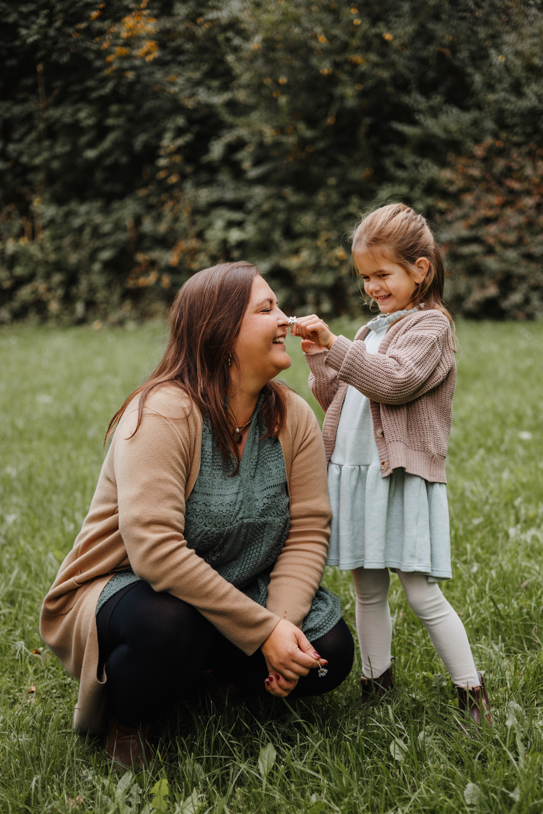Tochter hält ihrer Mama eine Blume hin beim liebevollen Mutter Kind Fotoshooting in Köln