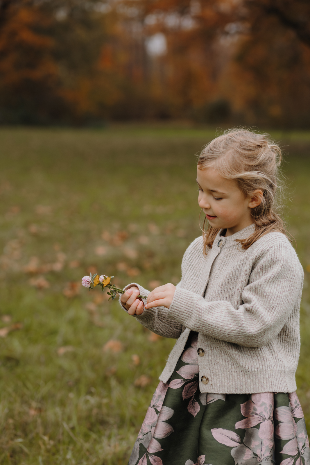 Mädchen schaut verträumt auf ihren gepflückten Blumenstrauß