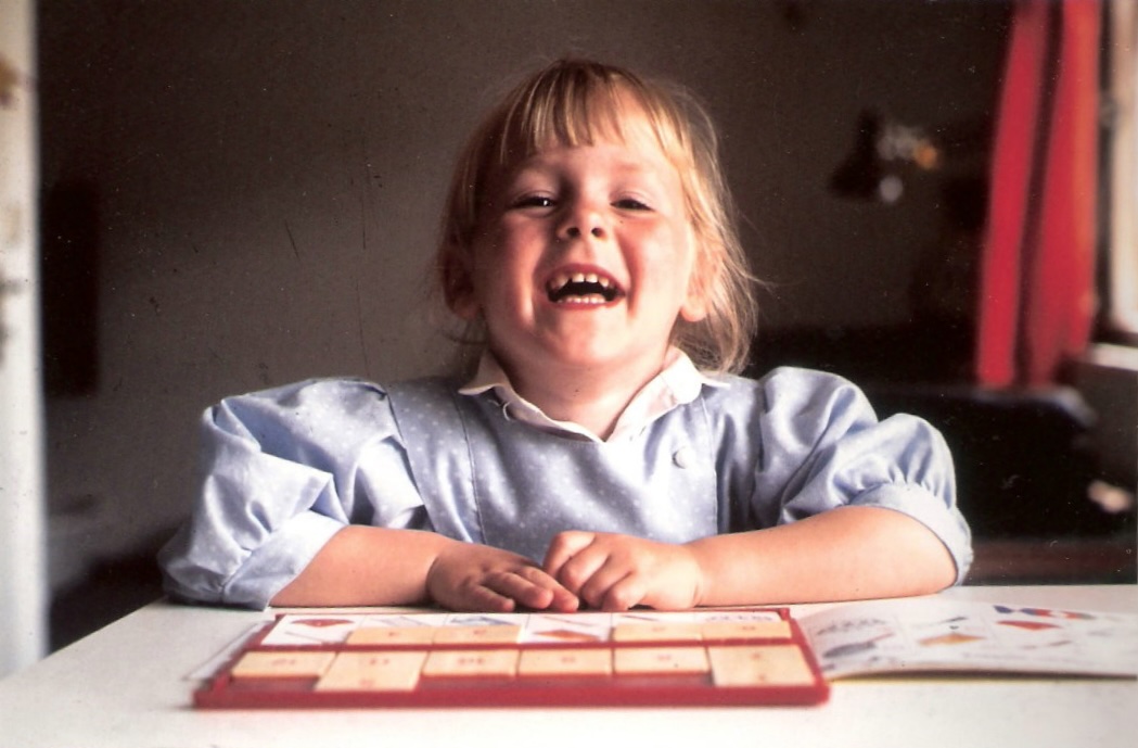 Mädchen lacht fröhlich in die Kamera