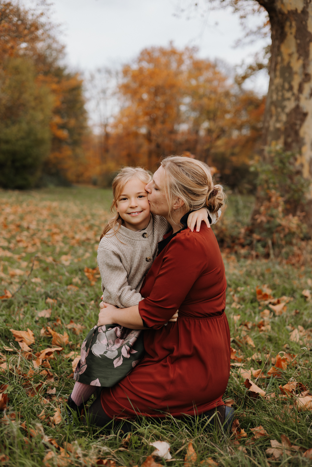 Mutter gibt Tochter einen Kuss auf die Wange beim Familien Fotoshooting in Köln